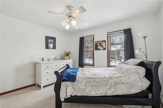 bedroom with a ceiling fan, light carpet, and baseboards