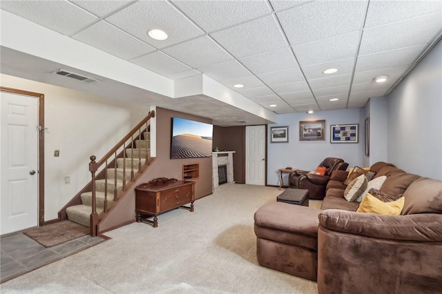 living area featuring light carpet, visible vents, a glass covered fireplace, stairs, and recessed lighting