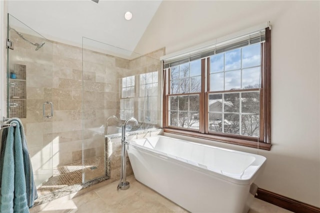 full bathroom featuring lofted ceiling, a freestanding tub, and a shower stall