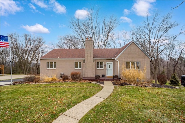 ranch-style home with a chimney, a front lawn, and brick siding