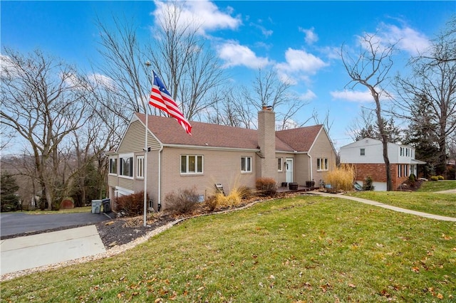 ranch-style house featuring brick siding, a chimney, and a front lawn