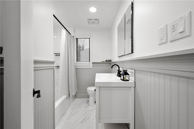 bathroom featuring a wainscoted wall, vanity, visible vents, marble finish floor, and shower / bath combo with shower curtain