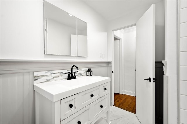 bathroom with a wainscoted wall and vanity