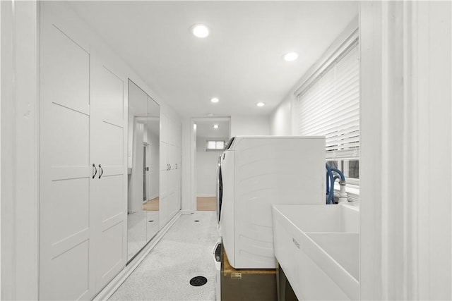 interior space with washer / clothes dryer, a sink, and recessed lighting