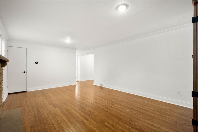 unfurnished living room with visible vents, crown molding, baseboards, and wood finished floors