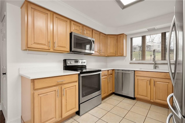 kitchen with light tile patterned floors, stainless steel appliances, light countertops, ornamental molding, and a sink