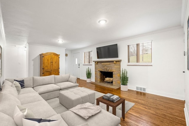 living area with ornamental molding, light wood finished floors, visible vents, and baseboards