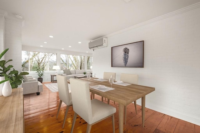 dining area with brick wall, crown molding, an AC wall unit, and wood finished floors