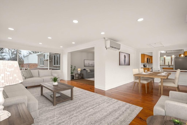 living area featuring recessed lighting, a wall unit AC, and wood finished floors