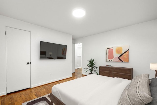 bedroom featuring baseboards and wood finished floors