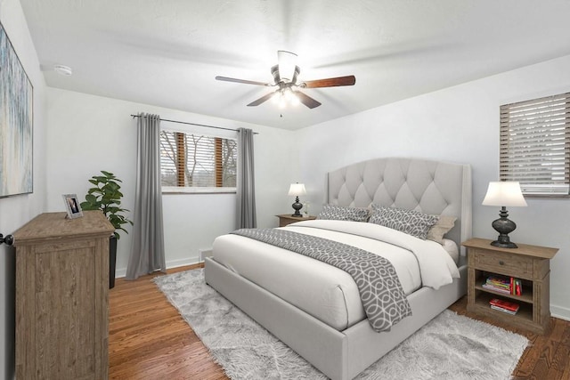 bedroom featuring baseboards, a ceiling fan, and wood finished floors