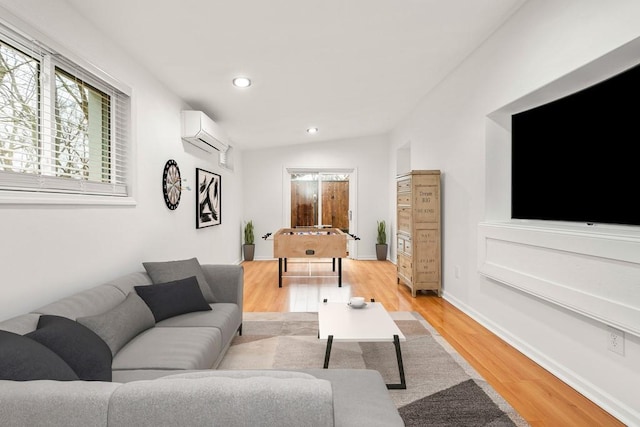 living area featuring lofted ceiling, recessed lighting, a wall unit AC, and light wood-style floors