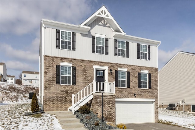 view of front of home with driveway, a garage, cooling unit, and brick siding