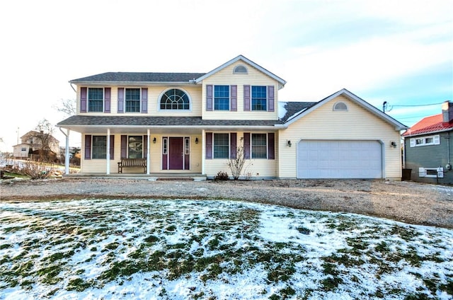 view of front of home featuring driveway, covered porch, and a garage