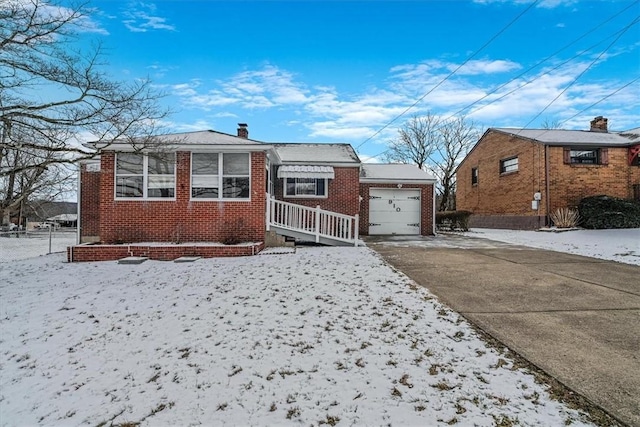 view of front of property with a garage, brick siding, driveway, and a chimney