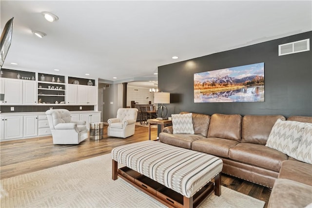 living room featuring light wood-style floors, visible vents, and recessed lighting