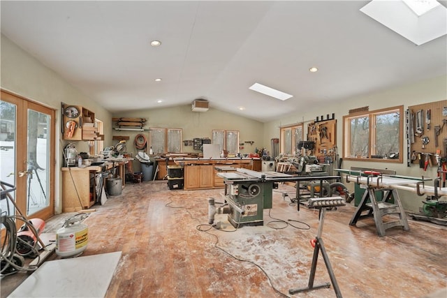 misc room with lofted ceiling with skylight, recessed lighting, a workshop area, and french doors