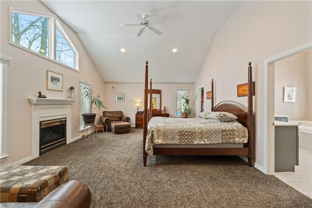 bedroom featuring light carpet, recessed lighting, high vaulted ceiling, and a glass covered fireplace