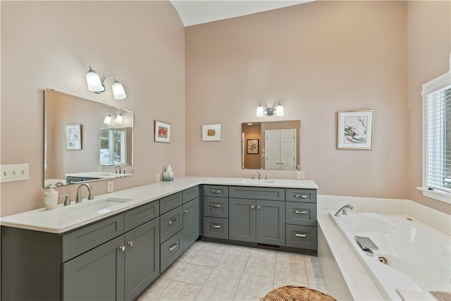 full bath featuring tile patterned flooring, a garden tub, and vanity