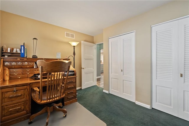 office area featuring baseboards, visible vents, and dark colored carpet