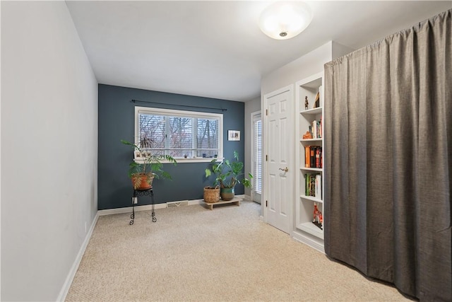 living area featuring light carpet and baseboards