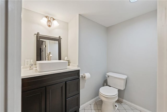 half bath featuring toilet, baseboards, vanity, and tile patterned floors