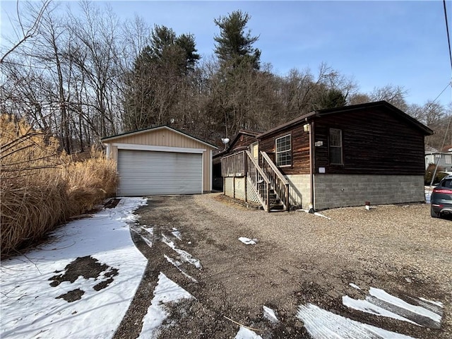 view of front of house with a garage, an outbuilding, and stairway