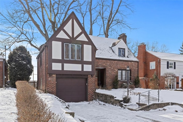 english style home featuring stucco siding, a chimney, and brick siding