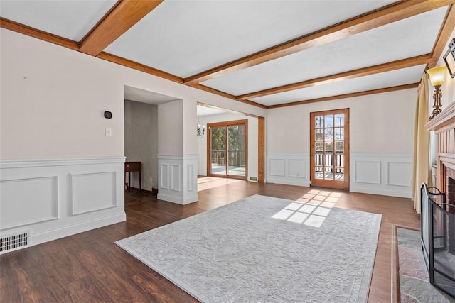 living area featuring a decorative wall, a fireplace, visible vents, beam ceiling, and dark wood finished floors