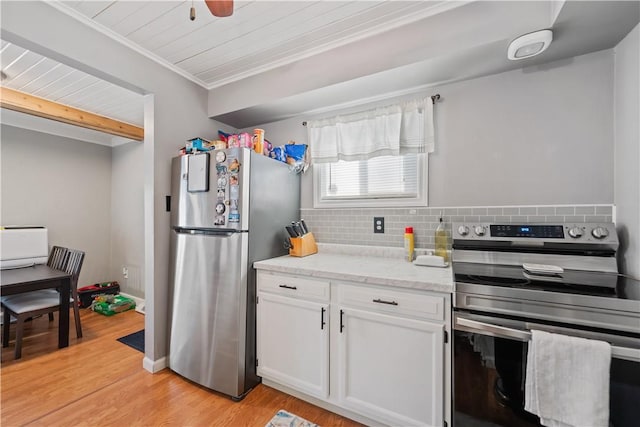 kitchen with light stone counters, white cabinetry, appliances with stainless steel finishes, decorative backsplash, and light wood finished floors