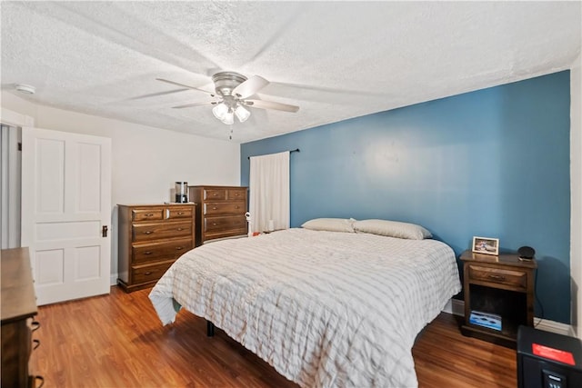 bedroom featuring ceiling fan, a textured ceiling, and wood finished floors