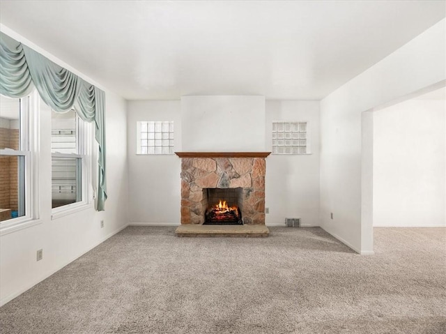 unfurnished living room featuring carpet floors, visible vents, and a fireplace