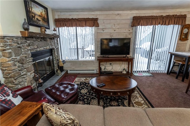 living area featuring a baseboard heating unit, a fireplace, and carpet flooring