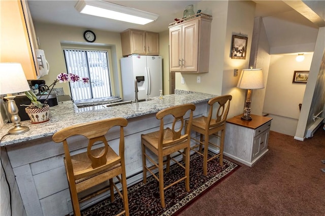 kitchen with dark colored carpet, light stone countertops, white appliances, a peninsula, and a kitchen breakfast bar