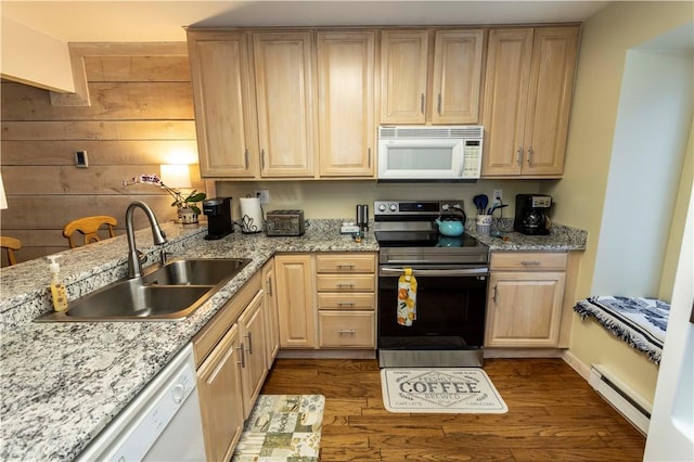 kitchen featuring light brown cabinetry, dark wood-type flooring, a baseboard heating unit, a sink, and white appliances