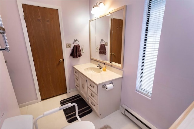 bathroom featuring toilet, a baseboard heating unit, and vanity