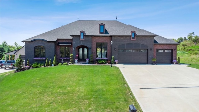 french provincial home featuring driveway, an attached garage, french doors, a front yard, and brick siding