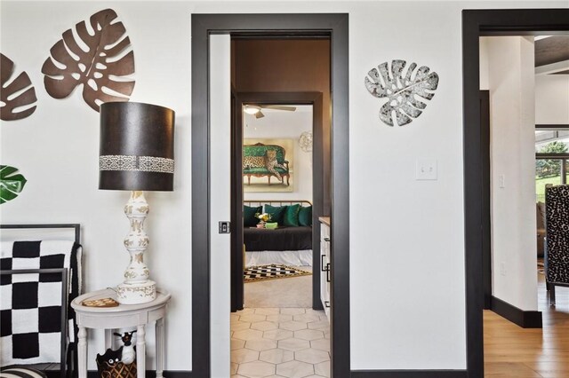 corridor featuring light wood-style flooring and baseboards