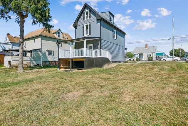 back of property featuring covered porch and a yard