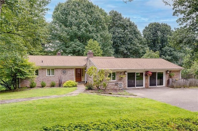 ranch-style house with a front lawn and brick siding