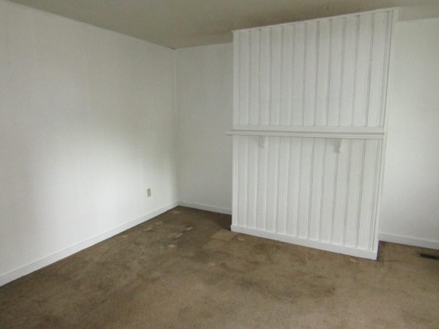 carpeted empty room featuring baseboards