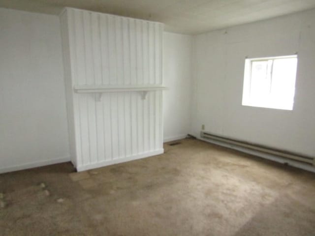 carpeted spare room with baseboard heating