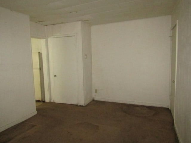 unfurnished room with baseboards