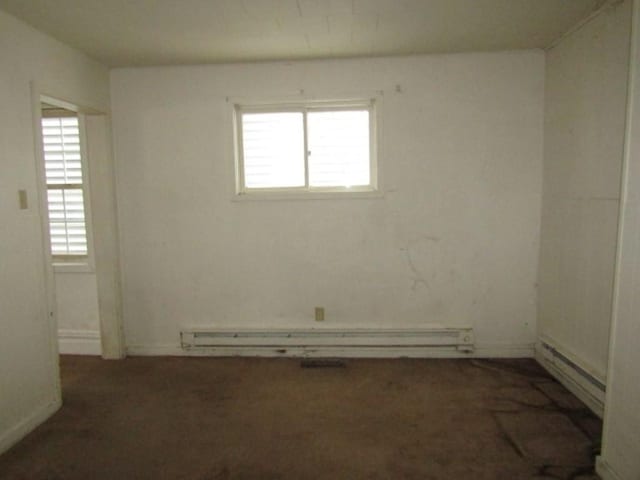 empty room featuring a baseboard radiator, healthy amount of natural light, and carpet
