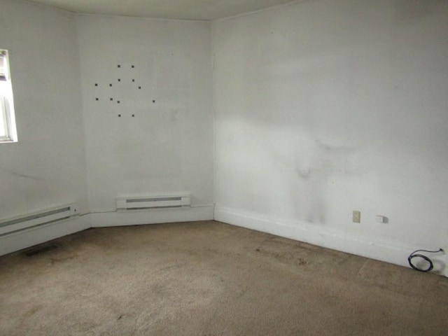 unfurnished room with baseboard heating, carpet floors, and baseboards