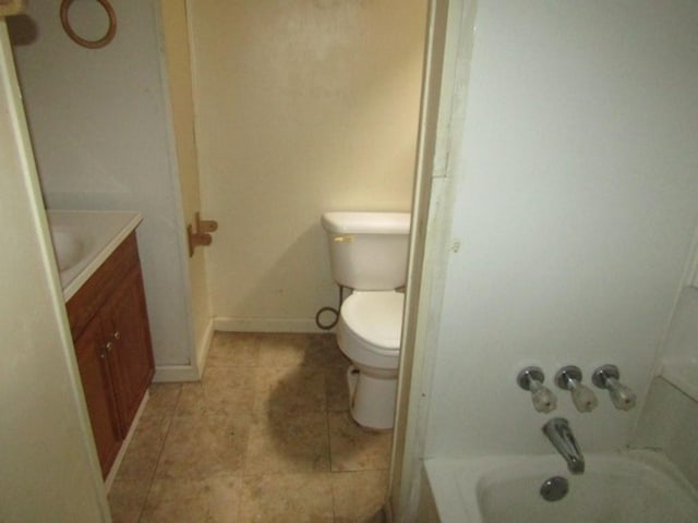 full bath featuring toilet, tile patterned floors, vanity, and baseboards