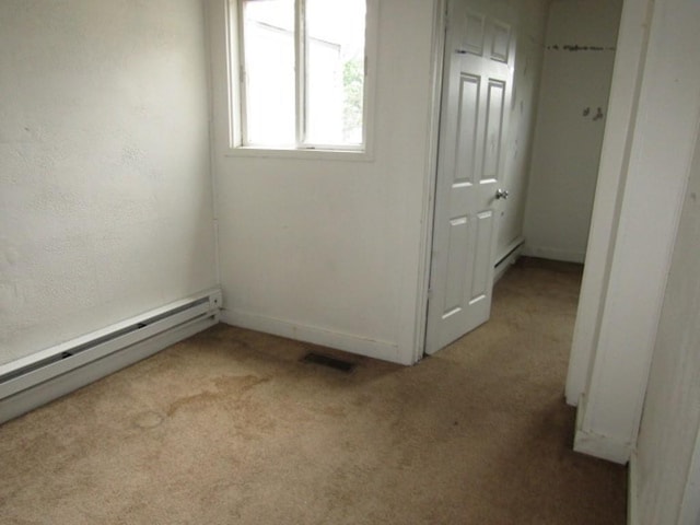 unfurnished room featuring light carpet, a baseboard radiator, and a baseboard heating unit