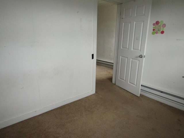 carpeted empty room featuring a baseboard radiator and baseboards