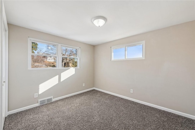 carpeted spare room with visible vents and baseboards