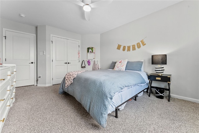 bedroom featuring a ceiling fan, a closet, light colored carpet, and baseboards